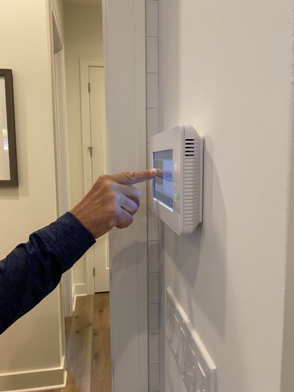 a-man-is-setting-his-alarm-on-a-security-panel-in-his-smart-home-.jpg a-man-is-setting-his-alarm-on-a-security-panel-in-his-smart-home-.jpg